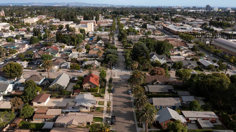 Aerial view of suburb in Orange, California with streets lined with palm trees.